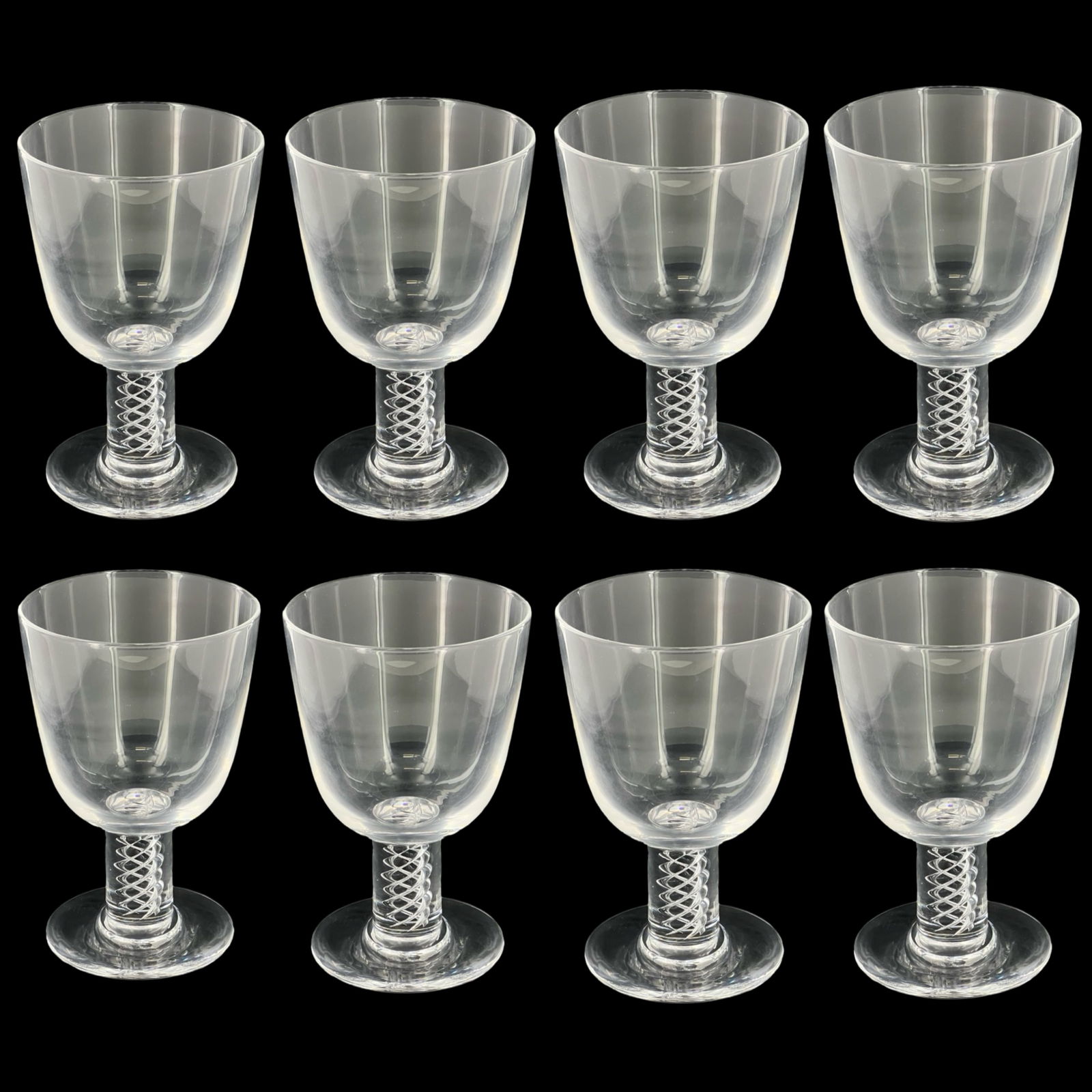 8 Steuben Airtwist Glass Spiral Stem Wine Goblets: This elegant set of eight Steuben red wine goblets showcases a classic mid-century design. Created by George Thompson in 1950, these goblets are distinguished by their beautiful airtwist spiral stem,