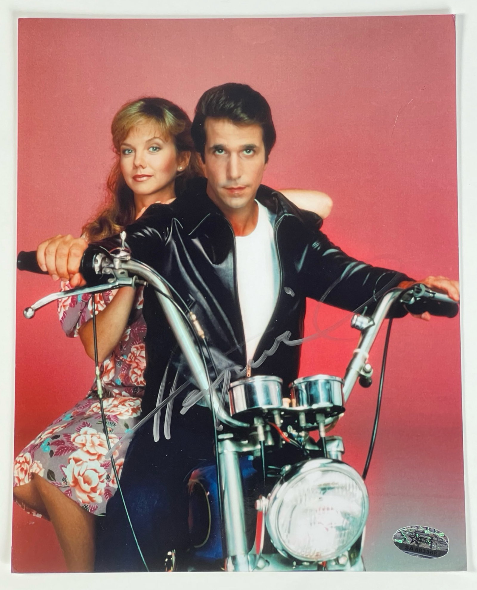 Henry Winkler as "The Fonz" Autographed Photograph: A vibrant autographed photograph featuring Henry Winkler as his iconic character, The Fonz, from Happy Days, posing on a motorcycle. Signed clearly in silver ink.8" x 10" No COA.PLEASE READ BEFORE BID