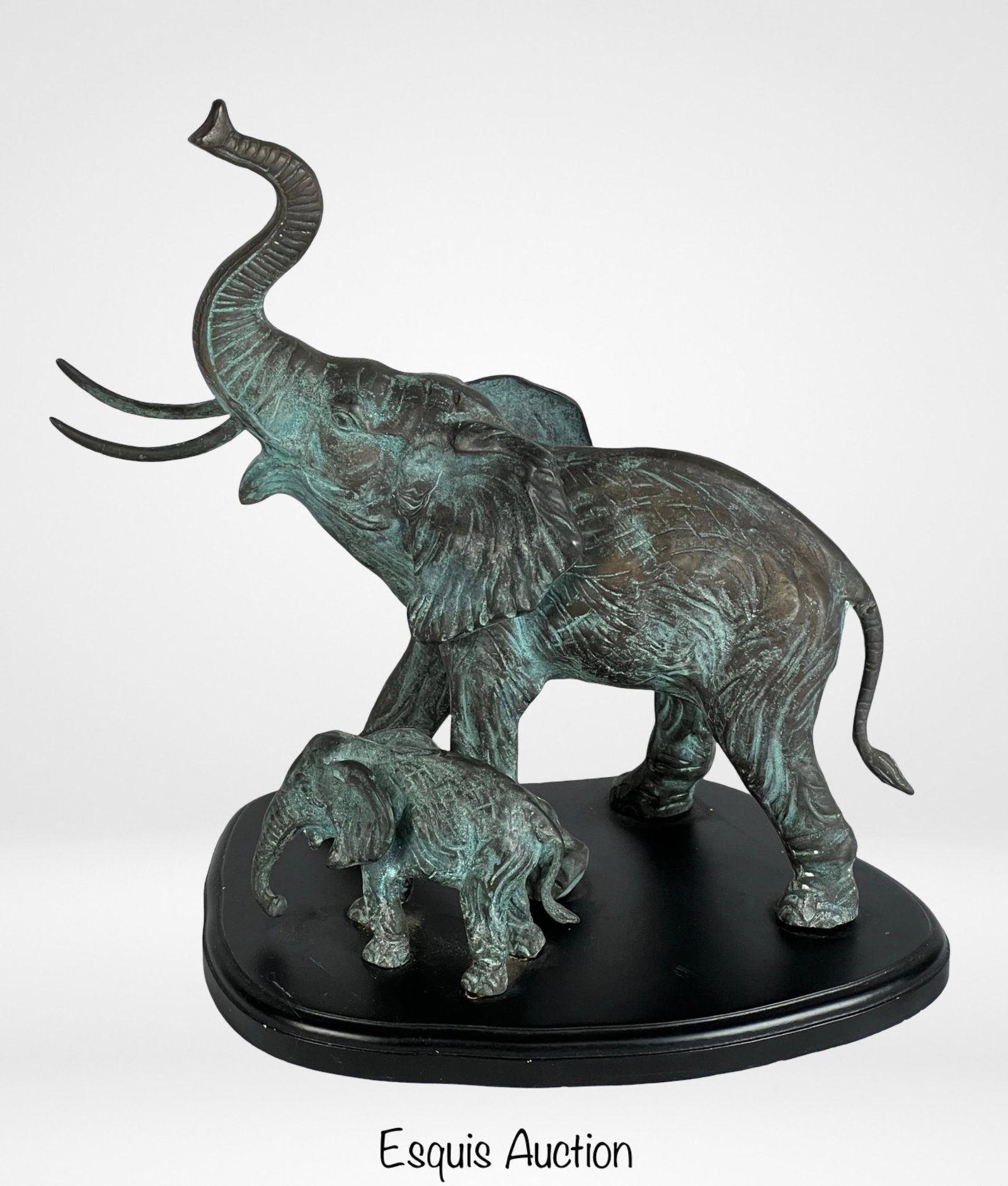Elephant Mother & Baby Bronze Sculpture: This bronze sculpture features a majestic elephant and its calf in an uplifting stance, with the adult elephant's trunk raised high. The intricate detailing captures the strength and grace of these cr