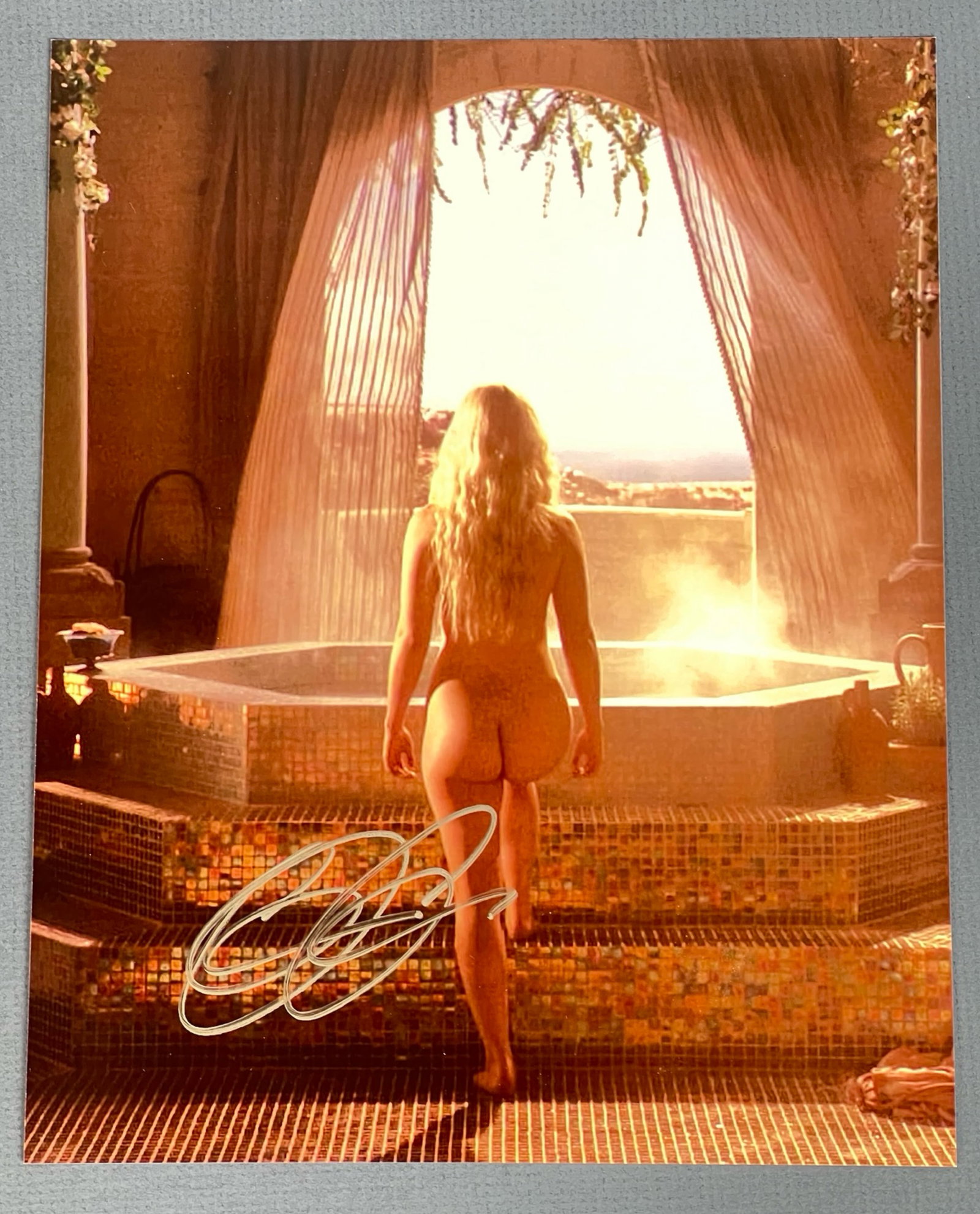 Emilia Clarke "Game of Thrones" Signed Sexy Photo: A captivating autographed photograph of Emilia Clarke, known for her role as Daenerys Targaryen in Game of Thrones. The image showcases Clarke in one of the series' most iconic scenes, beautifully sig