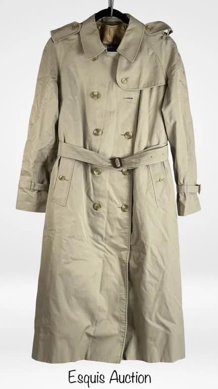 Burberrys London Lady's Trench Coat Sz 16 Long: This classic Burberrys trench coat for women features the iconic double-breasted front with a belted waist and shoulder epaulets. Made in England, the coat showcases the brand's signature check lining