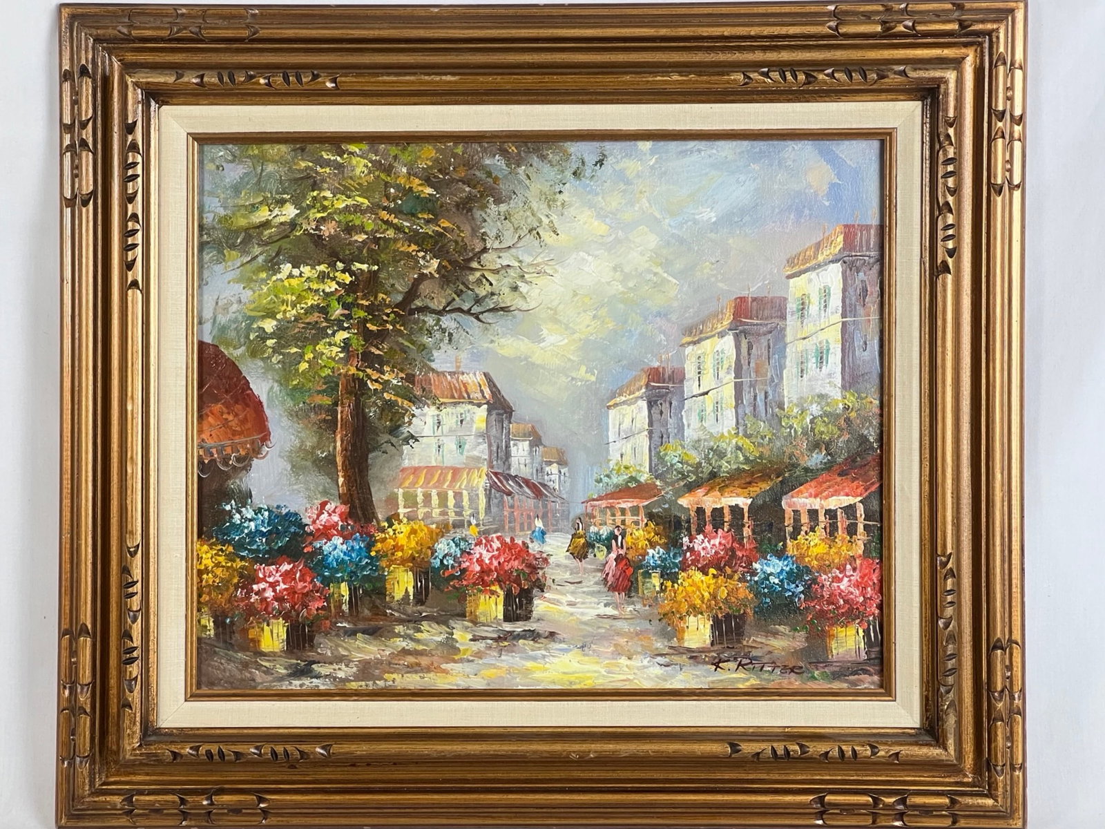 K. Ritter - Flower Market Oil Painting: A vibrant and lively oil painting on canvas by K. Ritter, showcasing a bustling flower market scene in a quaint European village. The composition bursts with color, as floral arrangements in vivid hue