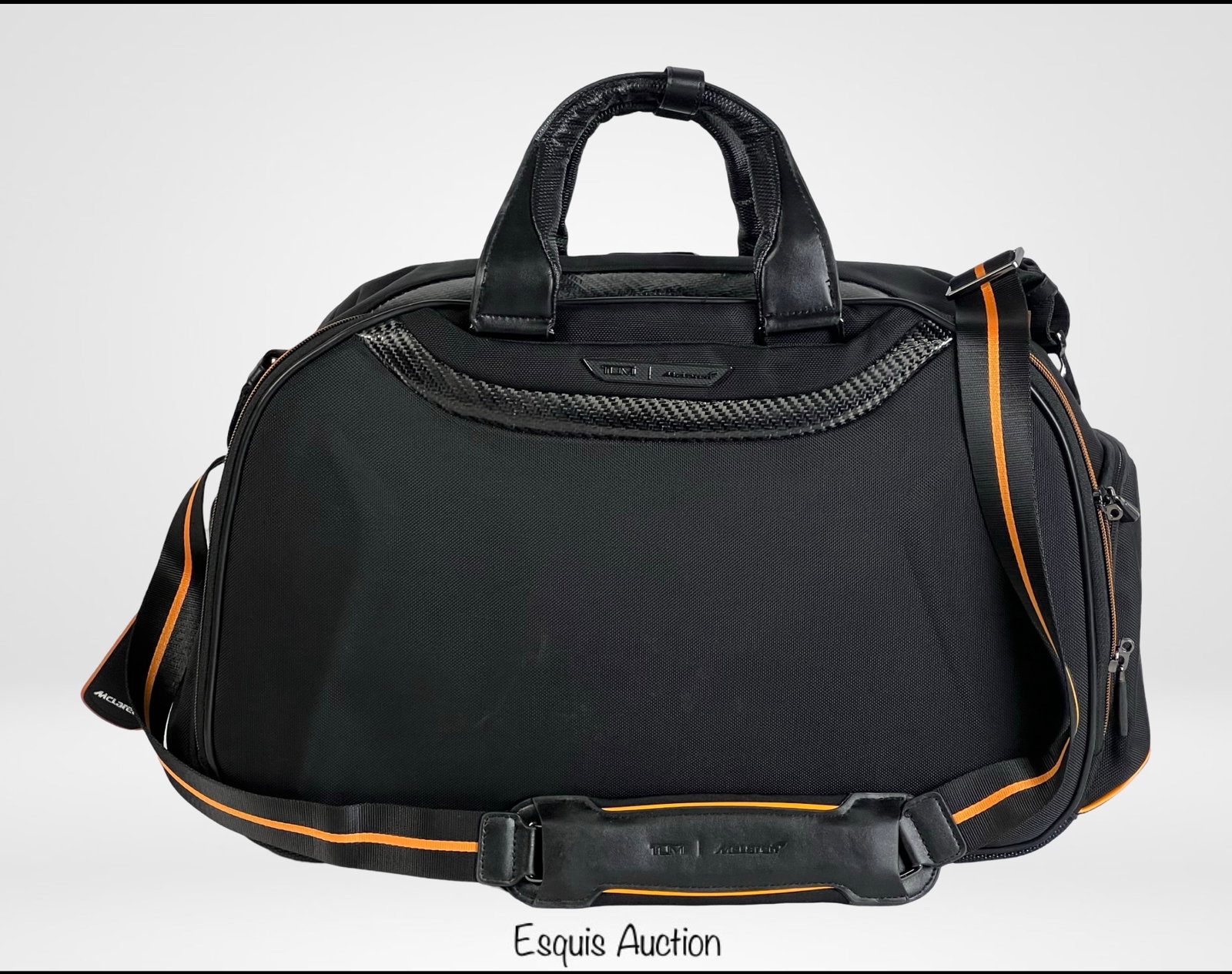 Tumi McLaren Quantum Duffel Bag: Tumi McLaren Quantum Duffel Bag, crafted with premium materials for durability and modern style. Measuring approximately 19" x 13" x 8", this bag features a sleek black exterior accented with carbon-f