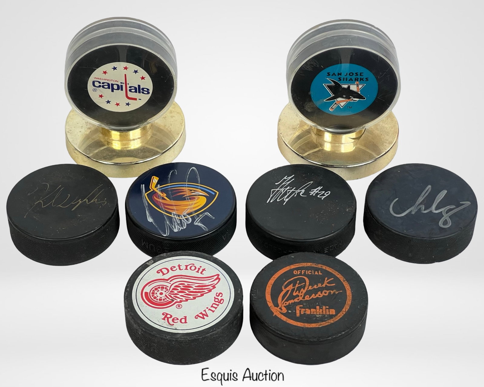 8 Autographed & Commemorative Hockey Pucks: Lot of eight hockey pucks, including autographed and commemorative pieces. Good overall condition, with signs of wear consistent with use.
