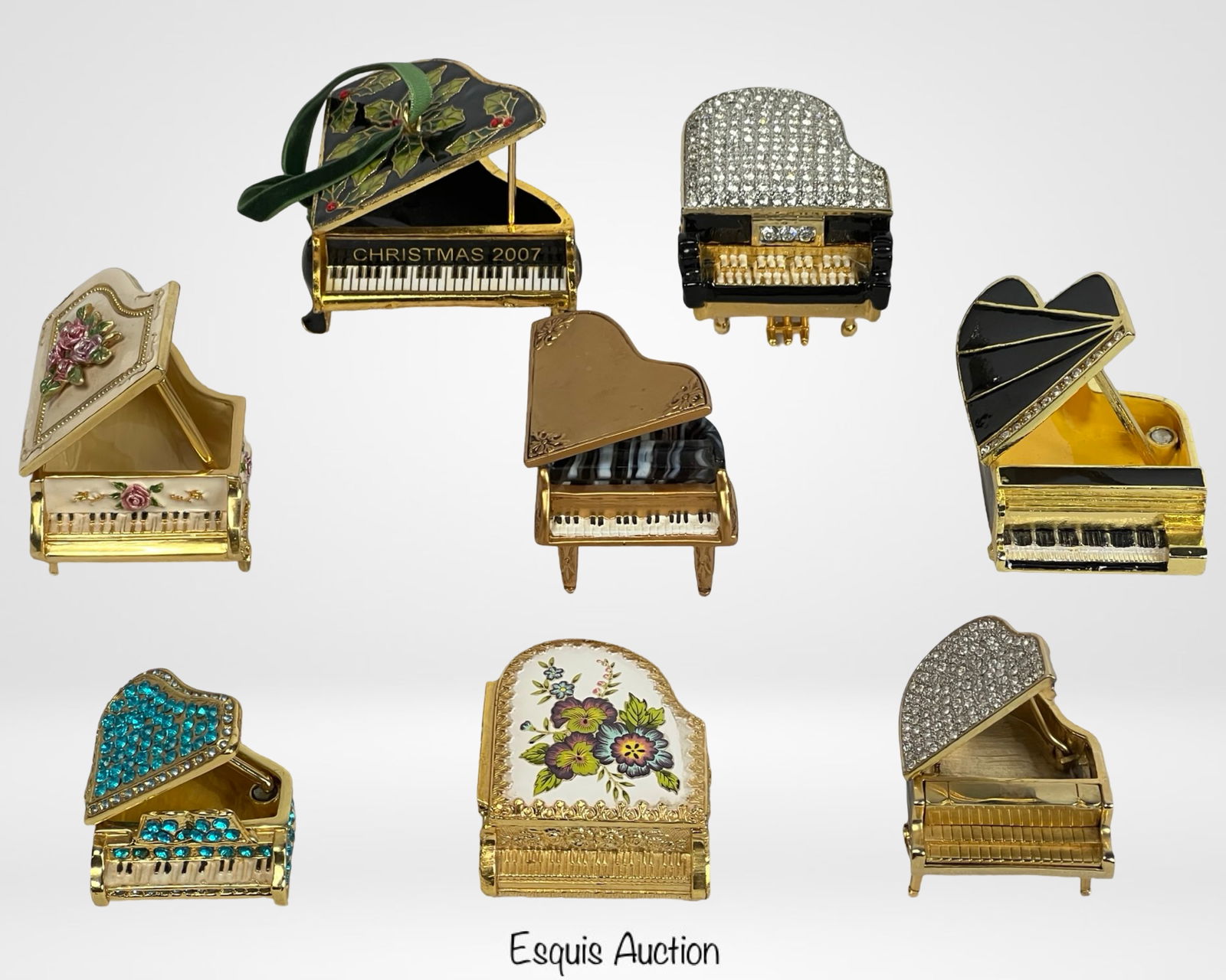 Miniature Grand Piano Trinket Boxes-Enamel & Rhine: A charming collection of seven miniature grand piano-shaped trinket boxes, each adorned with intricate enamel detailing, rhinestones, floral motifs, and gold-tone accents. These hinged boxes open to r