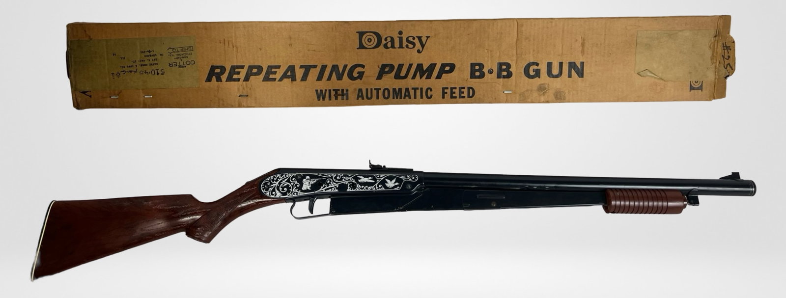 Daisy Model 25 Repeating Pump BB Gun w/ Box: Vintage Daisy Model 25 Repeating Pump BB Gun. This classic air rifle features an ornate engraved receiver with decorative scrollwork and hunting motifs. Comes with original box.