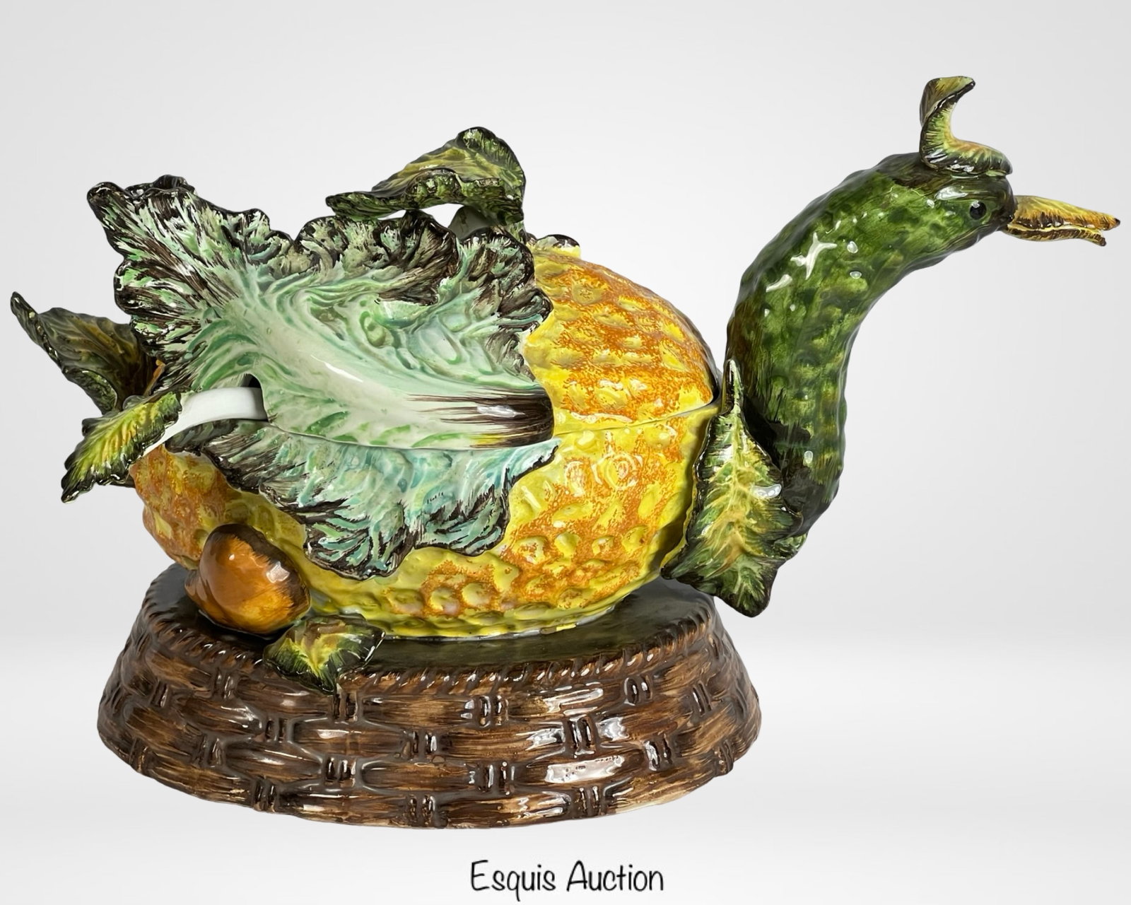 Italian Majolica Duck-Form Tureen: Whimsical Italian Majolica duck-shaped tureen, featuring a vibrant pineapple-textured body, green leafy lid, and an elongated neck with a detailed duck head. The tureen sits atop a woven-style ceramic