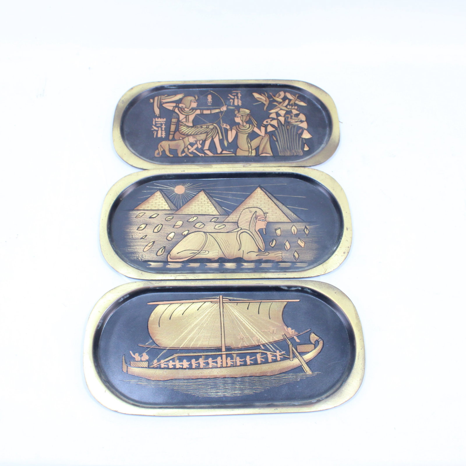 Set of Egyptian Themed Brass Trays: Set of three brass trays featuring detailed Egyptian-themed designs. Scenes include Egyptian Pharaoh Kingtut and Queen hunting Egypt Kemet King Tutankhamon; Egyptian Brass "Ancient Egyptian Scene" Pyr