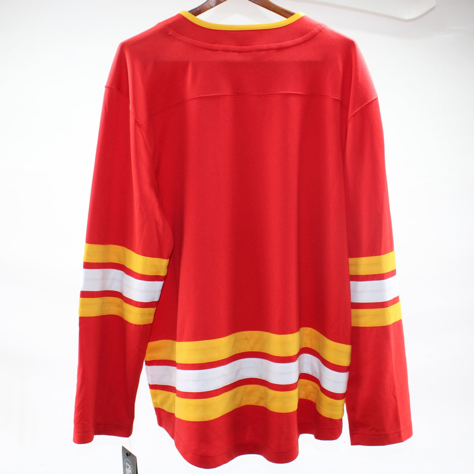 Calgary Flames NHL Jersey Size L: Support the Calgary Flames with this official NHL jersey in striking red and yellow. Featuring the iconic flaming 'C' logo, this jersey is perfect for any hockey enthusiast. Brand new with tags attach