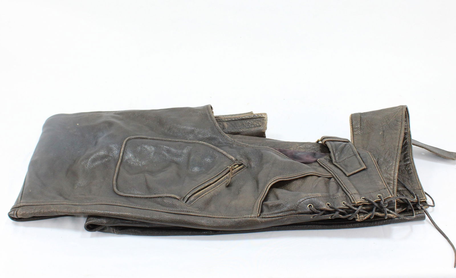 Vintage Leather Cowboy/ Biker Chaps: Pair of vintage leather cowboy chaps, featuring a rugged design perfect for horseback riding or Western-themed activities. The chaps have lace-up sides for an adjustable fit, along with a zippered poc