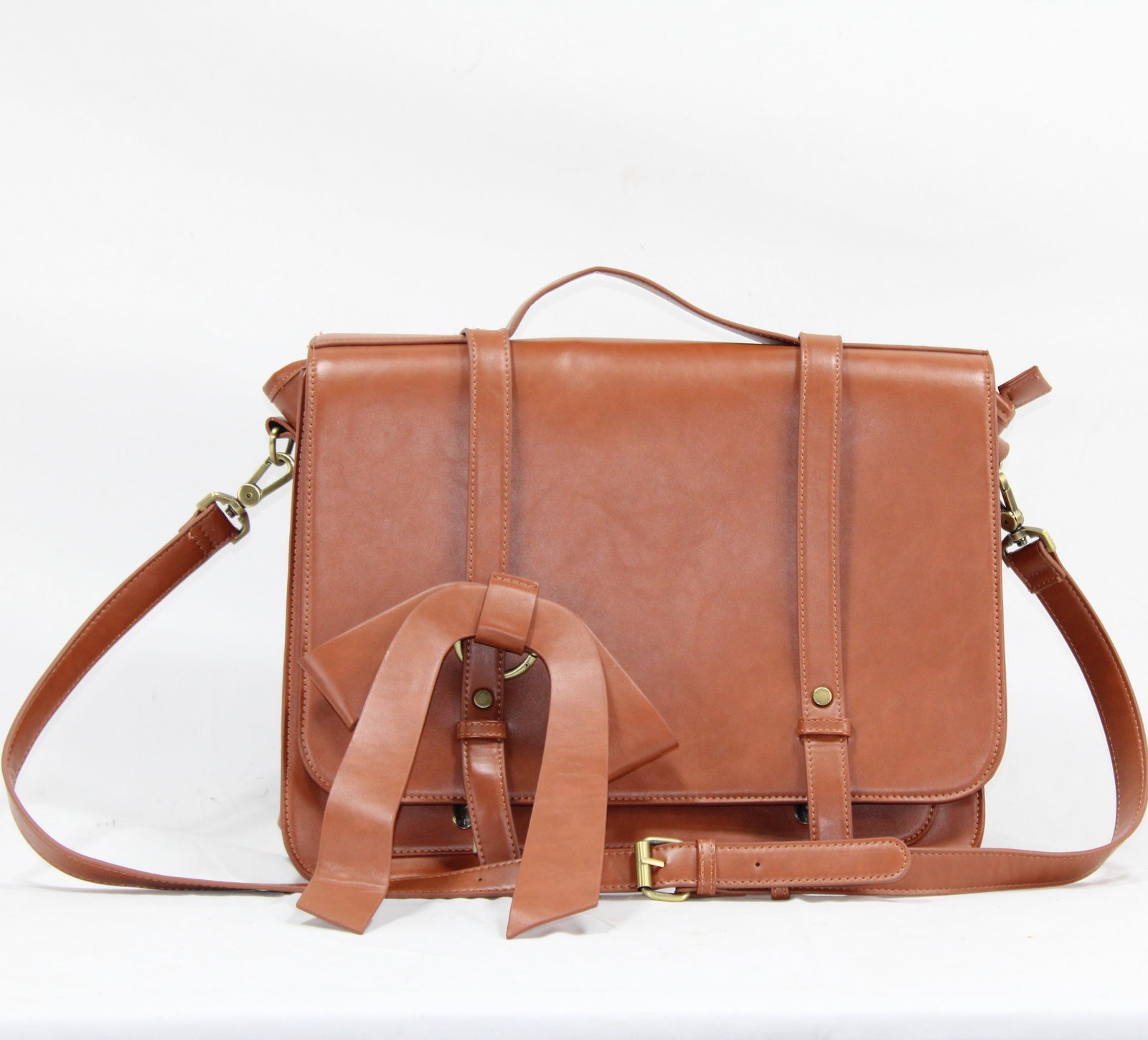 Vintage Leather Satchel with Bow and Adjustable Strap: Elegant brown leather satchel featuring decorative bow, adjustable shoulder strap, and brass hardware. Stylish and functional design with sturdy handle and secure buckle closures. Perfect for everyday