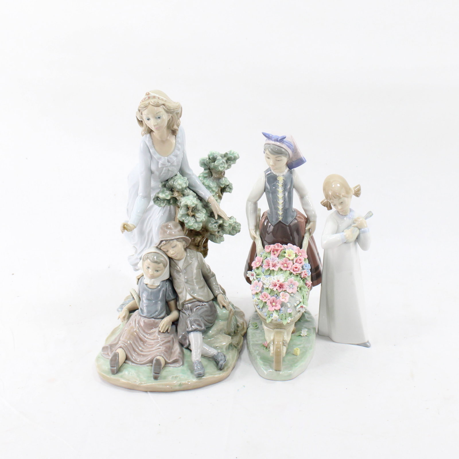 Lladro Collection of Porcelain Figurines ? Pastoral and Romantic Scenes: Exquisite collection of porcelain figurines showcasing idyllic and romantic scenes, including a mother with children, a young girl with a bouquet, and a floral wheelbarrow. Each piece is beautifully d
