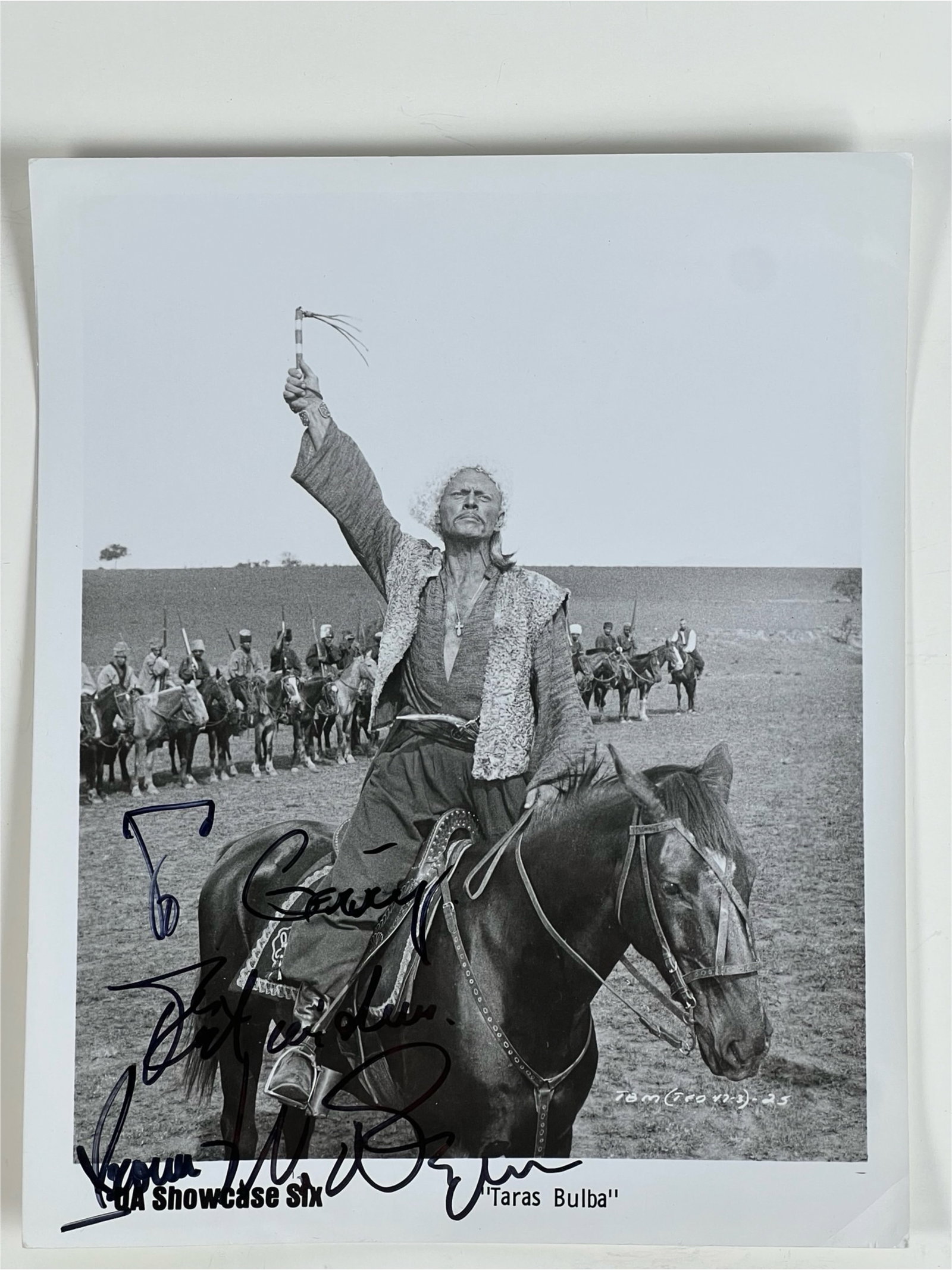 Yule Brenner Signed Taras Bulba Photo: Black-and-white photograph from Taras Bulba (1962), signed by Yule Brenner. The image features Brenner on horseback in costume for his role as Andrei Bulba. Inscription is addressed "To Garry." The si