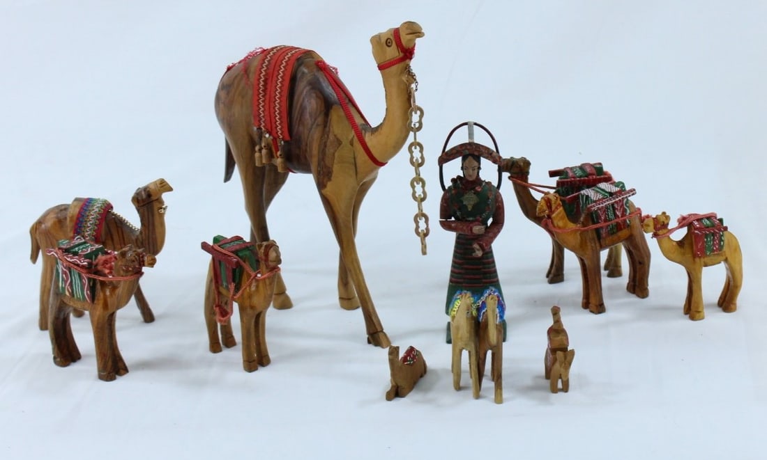 Hand Carved Bedouin Wooden Camel Figurines: This captivating collection features a set of hand-carved wooden camels accompanied by a detailed Bedouin handler, showcasing traditional craftsmanship. The set includes one large camel with ornate de
