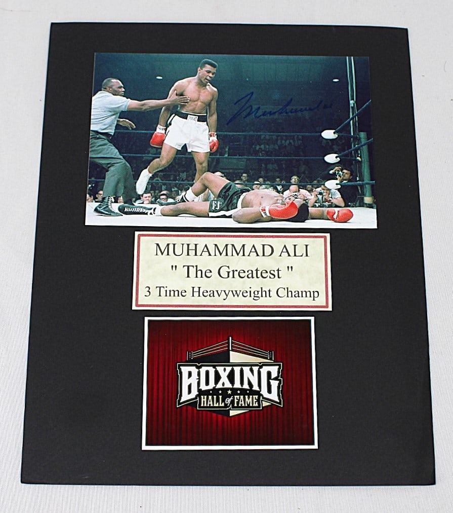 Muhammad Ali Boxing Hall of Fame Signed Photo: 8x10 photograph of Muhammad Ali in a triumphant boxing moment, signed by the legendary heavyweight champion. This photo highlights his legacy as a 3-time heavyweight champion and includes Hall of Fame