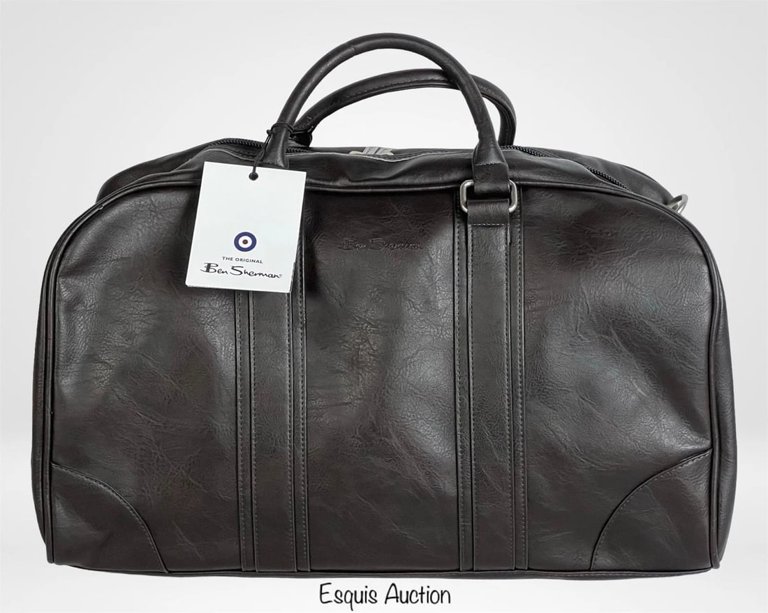 Ben Sherman Travel Weekender Carry-On Duffel Bag: Ben Sherman Weekender Duffel Bag in black vegan leather. Spacious and stylish with dual top handles, a detachable shoulder strap, and a fully lined interior. Measures 29" x 7.5" x 12.5", making it per