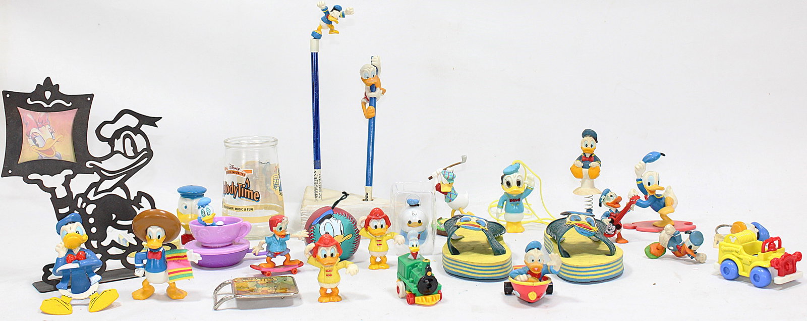 Disney Donald Duck Memorabilia Mixed Lot: A delightful collection of Donald Duck-themed collectibles, including figurines, toys, glassware, and unique items like flip-flops and pencil toppers. Perfect for Disney enthusiasts and collectors, th