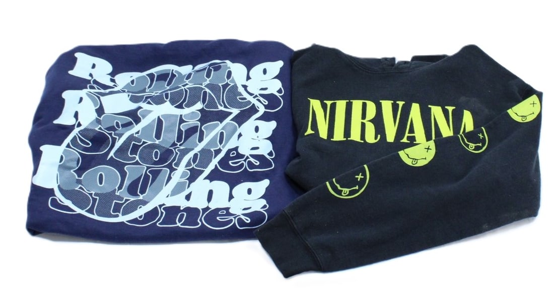 Nirvana and Rolling Stones Band Sweatshirts: Classic Rock Apparel Lot. Two iconic band sweatshirts featuring timeless designs. The Nirvana sweatshirt in size Small showcases the band's iconic smiley face logo in vibrant yellow on a black backgro