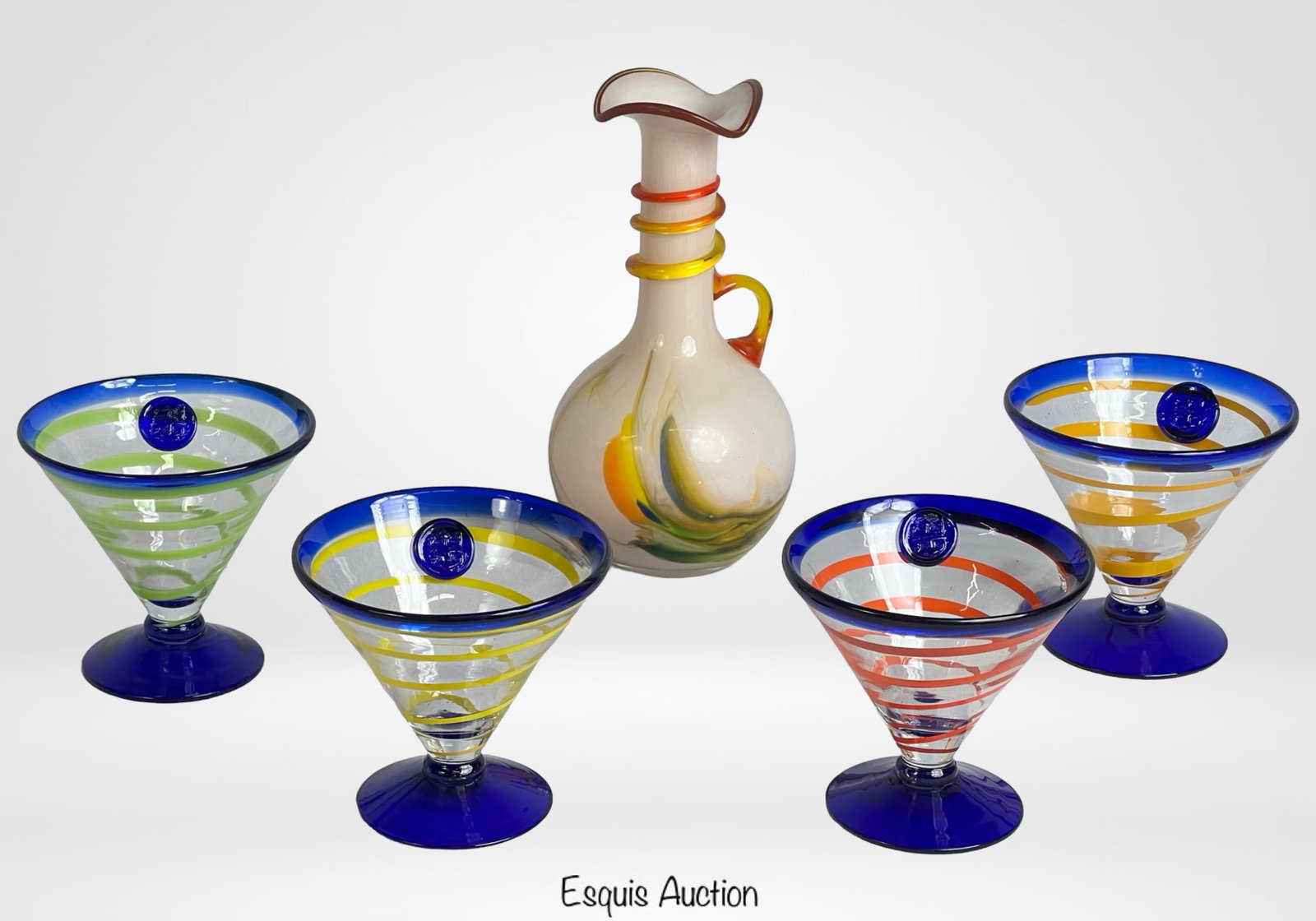 Murano Art Glass Vase & Kosta Boda Martini Glasses: Murano art glass vase with ruffled top, applied cobalt blue roping, and yellow handle, features soft pastel swirls in white, green, and orange tones. Vase measures 9.5 inches tall. Includes a set of f