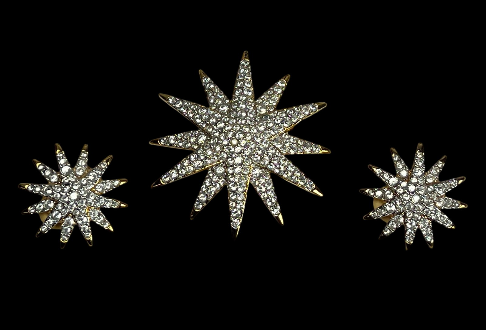 Swarovski Gold Tone Crystal Pave Star Jewelry Set: This dazzling vintage Swarovski jewelry set includes a large starburst brooch and matching clip-on earrings, all finished in brilliant gold tone metal and fully set with pave crystals. The brooch meas