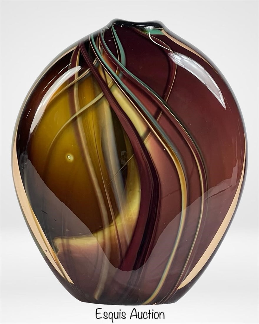 Stephen Jon Clements Hand Blown Art Glass Vase '83: This striking hand-blown art glass vase by American artist Stephen Jon Clements is a masterful display of fluid form and vibrant color. Created in 1983, the piece features an organic, flattened ovoid 