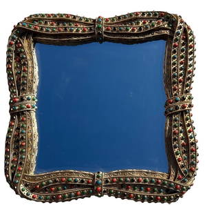 Moroccan Style Ornate Jeweled Wall Mirror by Adore: A beautifully crafted wall mirror featuring an ornate, Moroccan-style frame adorned with intricate detailing and colorful jewel-like embellishments in red, green, black, and blue. The curved, antique-