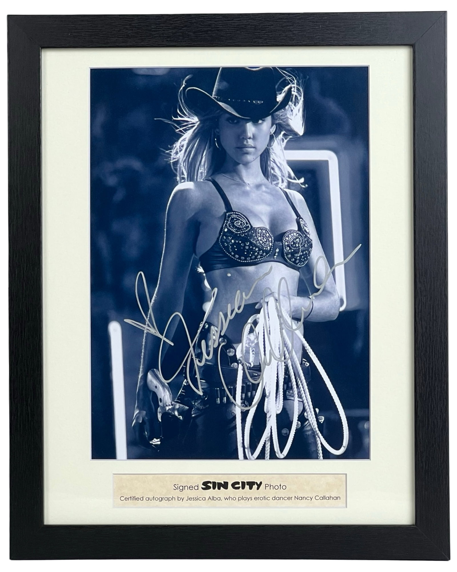 Jessica Alba Autographed Sin City Photograph: Black and white promotional photograph from Sin City, autographed by Jessica Alba, who portrayed Nancy Callahan in the 2005 neo-noir film. Alba is shown in her iconic cowgirl costume from the movie's 