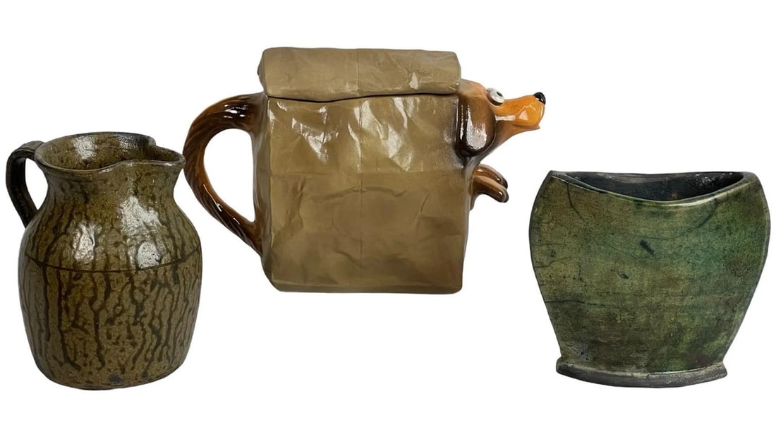 Art Pottery- John Groth, Matthew Hewell, Raku: This unique art pottery collection features three distinct pieces. The standout item is a whimsical ceramic teapot by John Groth, titled "Doggie Bag," with a sculptural design of a paper bag and a dog