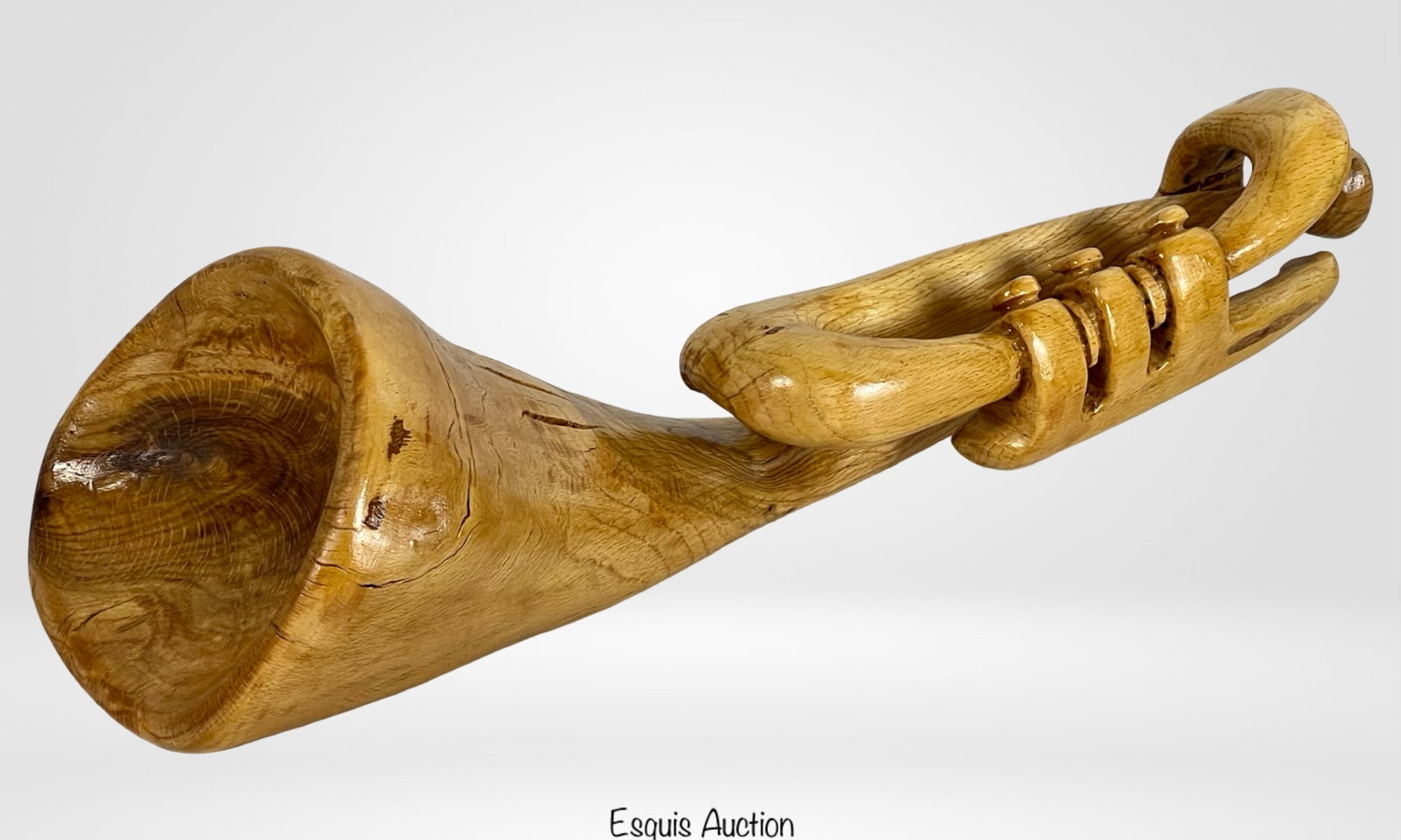 Hand-Carved Wooden Trumpet Sculpture: Impressive hand-carved wooden sculpture in the form of a trumpet, measuring approximately 17" long by 5" wide and 6" tall. Expertly shaped from a single piece of wood, this decorative piece showcases 