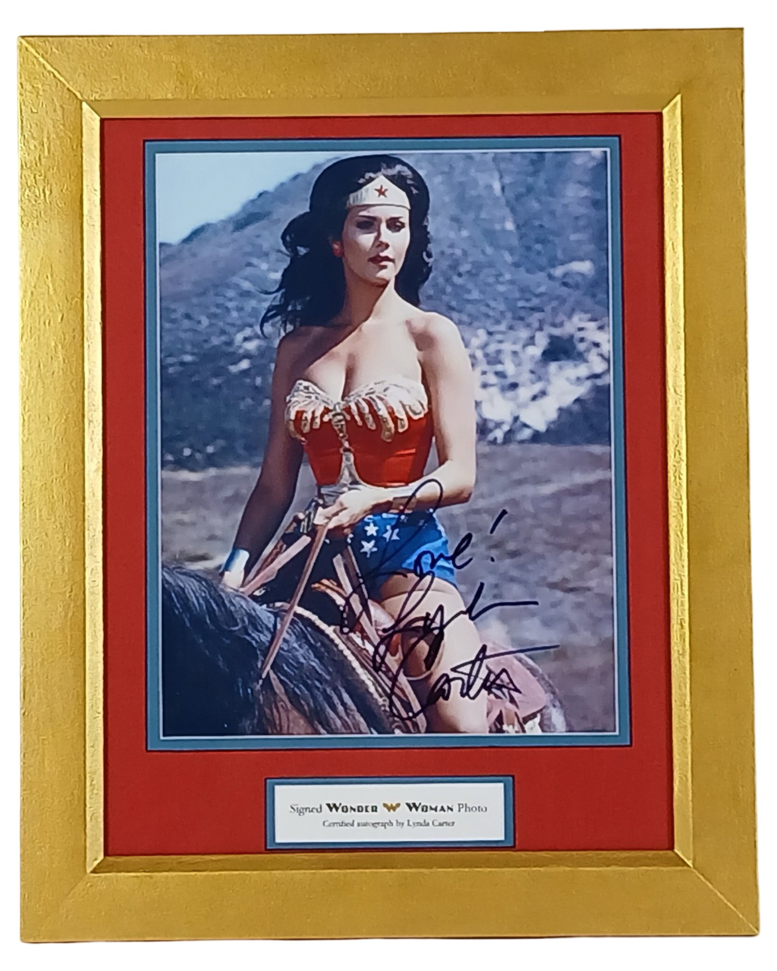 Wonder Woman - Lynda Carter Autographed Photo: Striking image of Lynda Carter as Wonder Woman on horseback, boldly signed by the iconic actress with the inscription "Love!" A vibrant tribute to the beloved superheroine, beautifully presented in a 