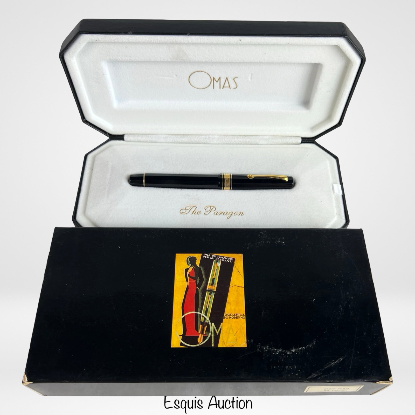 Omas "The Paragon" Fountain Pen with 18K Gold Nib: Omas "The Paragon" fountain pen, crafted in Italy and presented in its original clamshell case with outer box. Finished in classic black resin with gold-plated trim, the pen features the signature fac