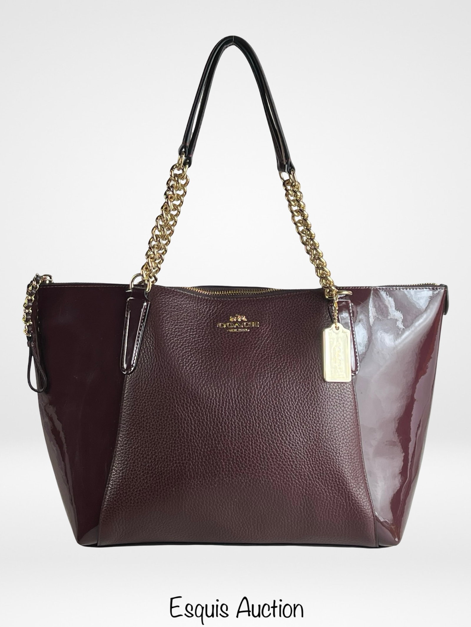 Coach Ava Chain Tote Shoulder Bag: Elegant and spacious Coach Ava tote featuring a rich burgundy exterior in a mix of pebbled leather and patent leather panels. Gold-tone chain and leather shoulder straps add a luxurious touch, while t