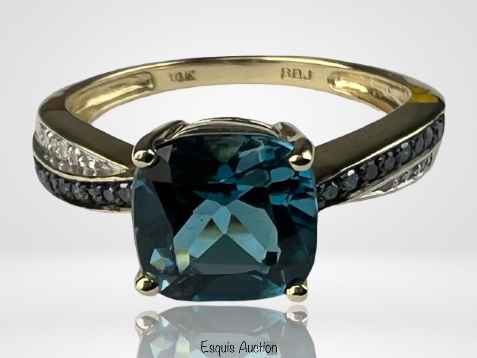 10k Yellow Gold Ladys Ring with London Blue Topaz: Elegant 10k yellow gold ring featuring a cushion-cut London blue topaz as the centerpiece, flanked by shimmering diamond accents along the shoulders. A timeless and versatile design that blends deep c