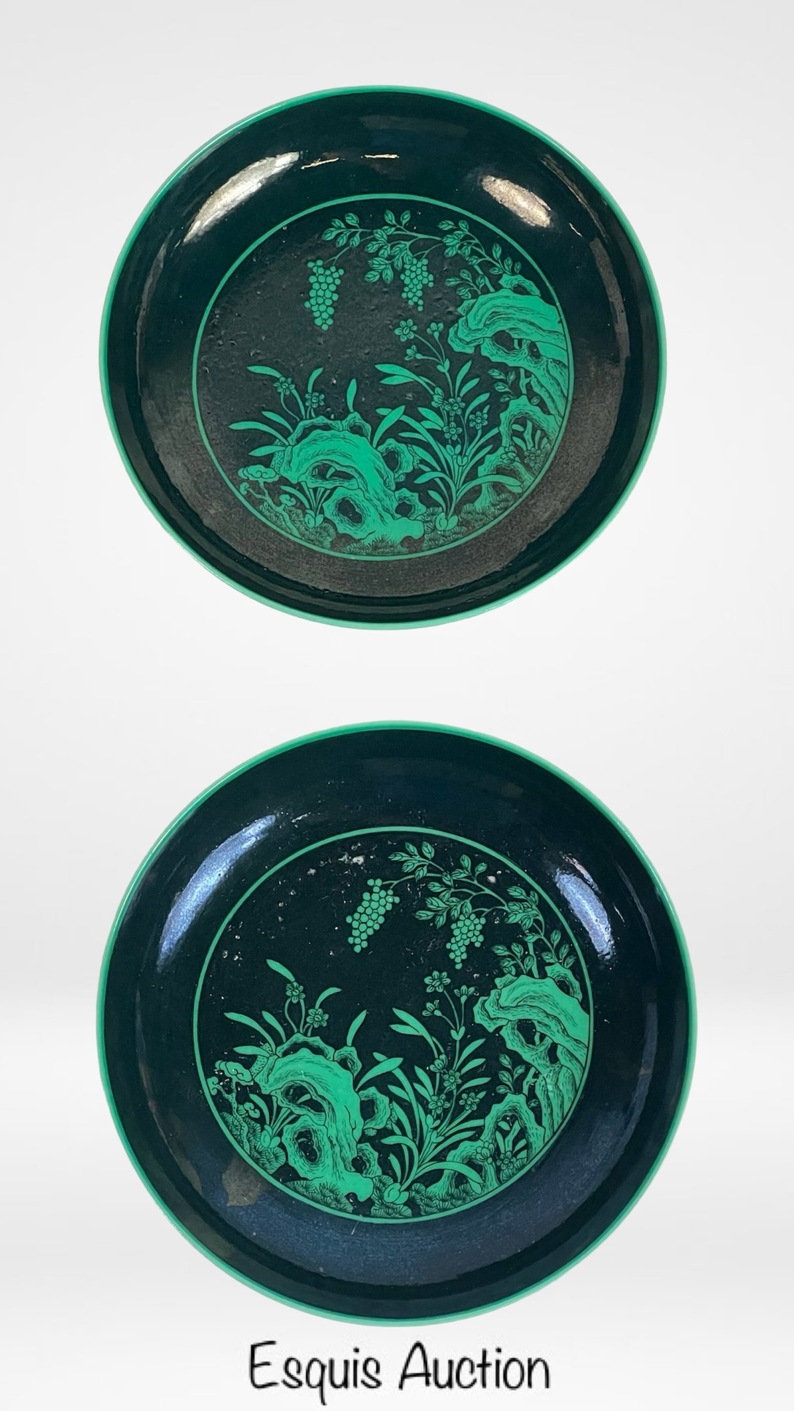 Chinese Qing Dynasty Yongzheng Enamel Plates: A superb matching pair of Chinese enamel plates from the Qing Dynasty, each measuring approximately 6 inches in diameter. Decorated with a vivid green floral and rockery motif on a black enamel ground