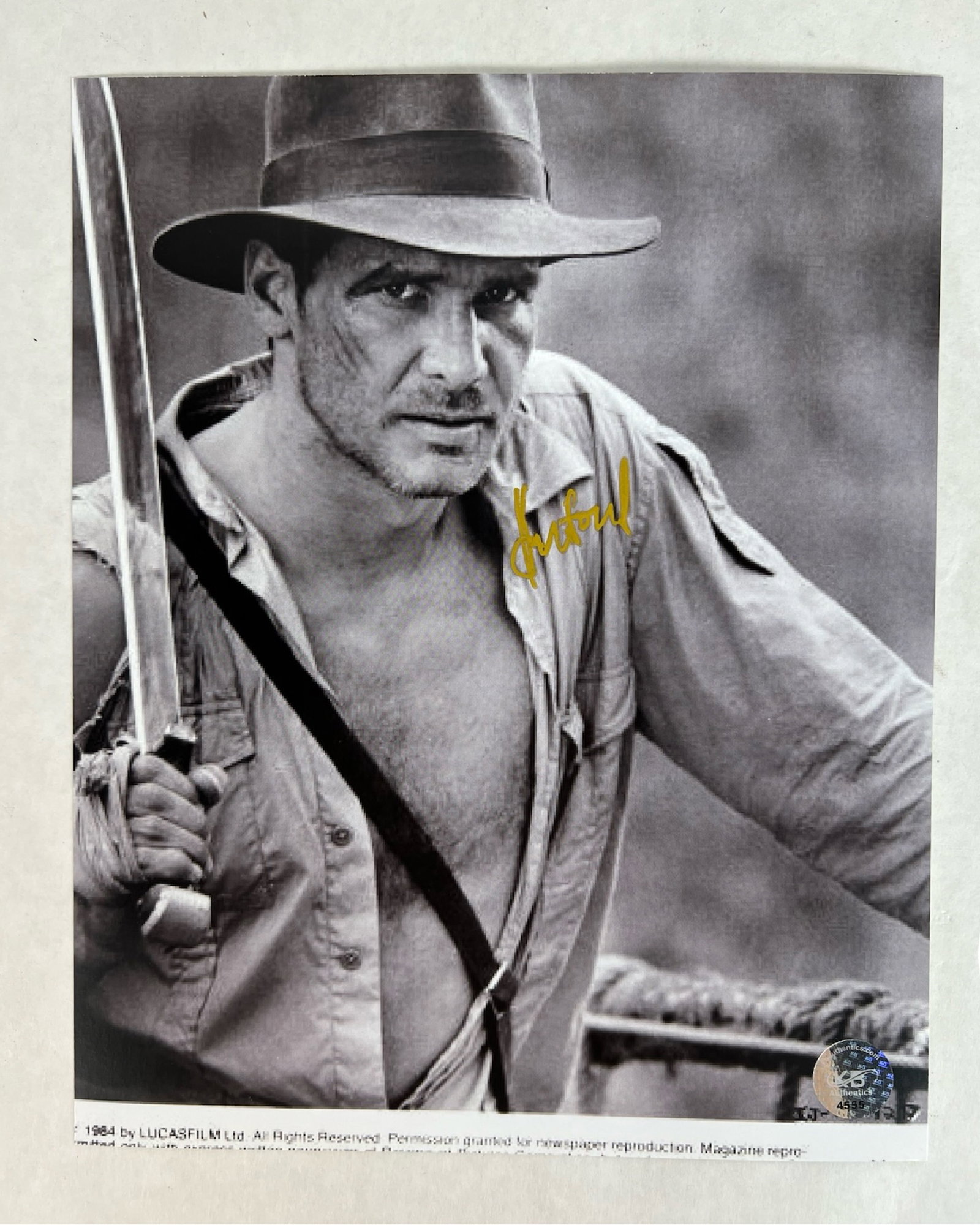 Harrison Ford Signed Indiana Jones Photograph: Signed photograph of Harrison Ford in his iconic role as Indiana Jones, from the 1984 adventure classic Indiana Jones and the Temple of Doom. Ford is shown in character with his trademark fedora and w