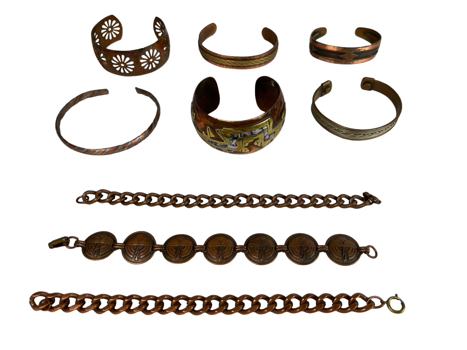 Vintage Copper and Brass Jewelry - Bracelets: harming assortment of vintage copper and brass jewelry, including seven cuff-style bracelets with various etched, twisted, and inlaid designs, along with three distinctive chain-link bracelets. One br