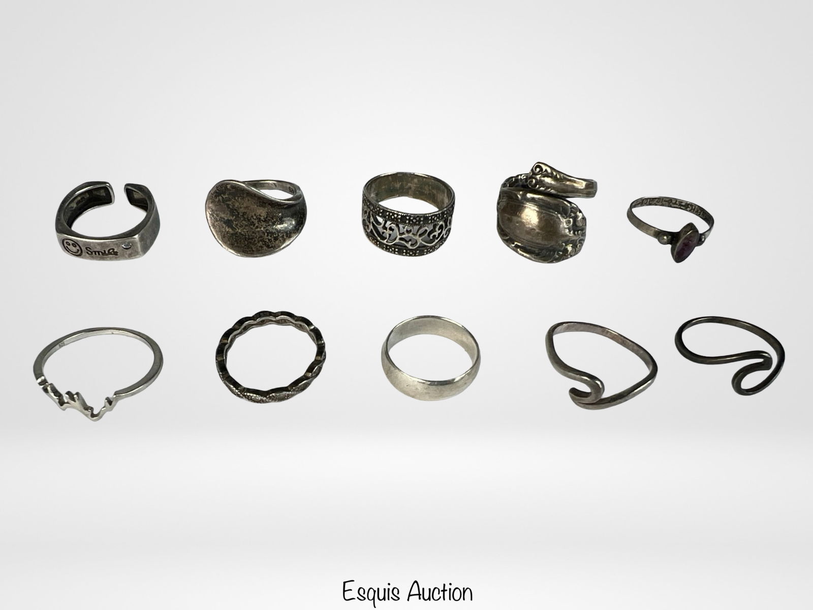 Assortment of Sterling Silver Rings: A varied collection of ten sterling silver rings featuring a mix of designs, including open bands, abstract shapes, engraved motifs, and a spoon-style wrap ring. A great lot for collectors, resellers,