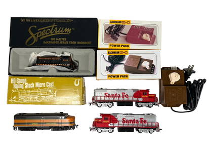 HO Scale Train Lot with Locomotives & Power Packs: HO scale model train lot including five locomotives and three power controllers. The lot features two boxed locomotives: a Bachmann Spectrum Southern Pacific #5108 diesel switcher in original packagin