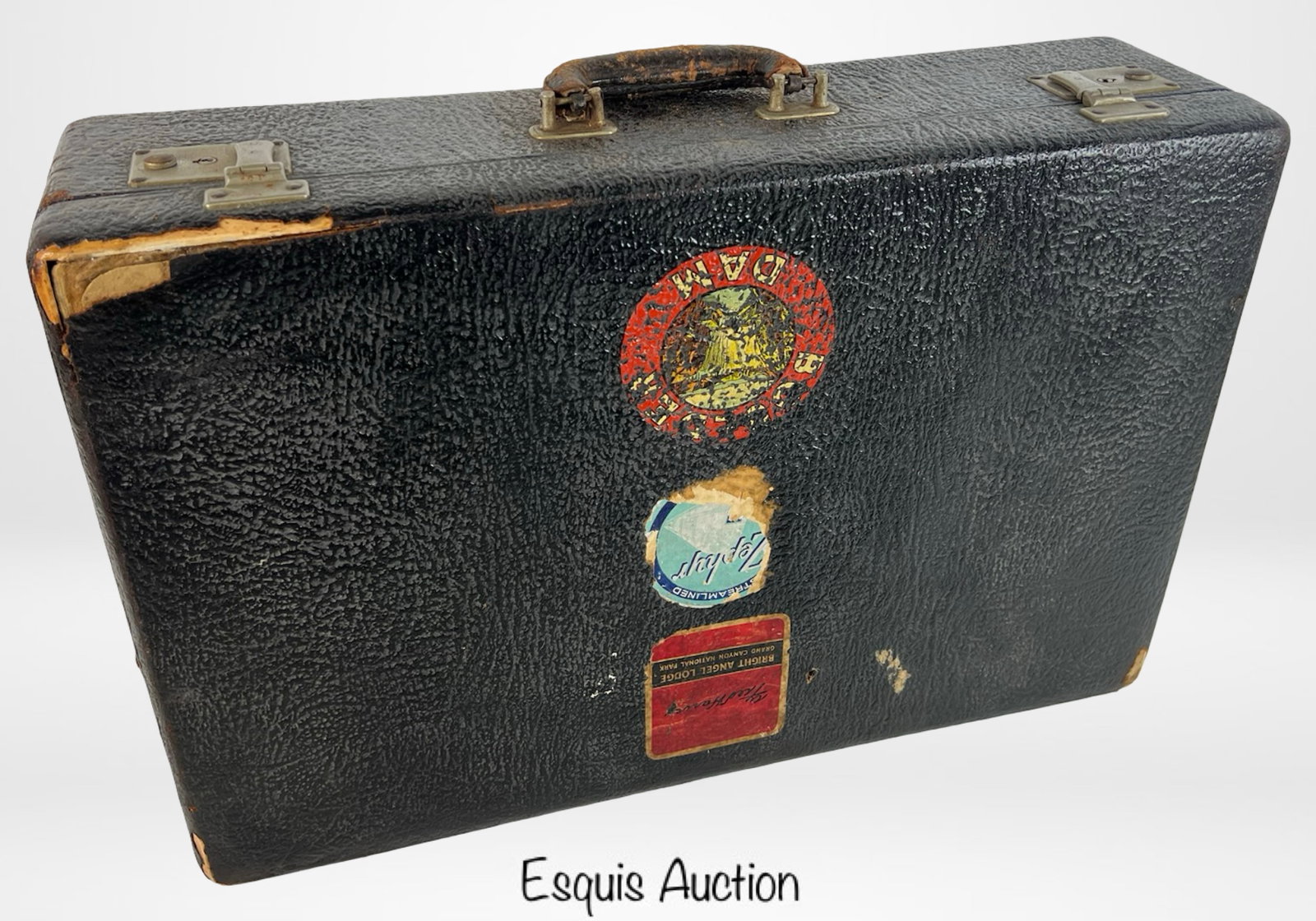 Antique Textured Black Travel Suitcase: A charming antique travel suitcase featuring a textured black exterior with remnants of vintage travel labels, adding nostalgic appeal. The case opens to reveal a vibrant green satin-lined interior wi