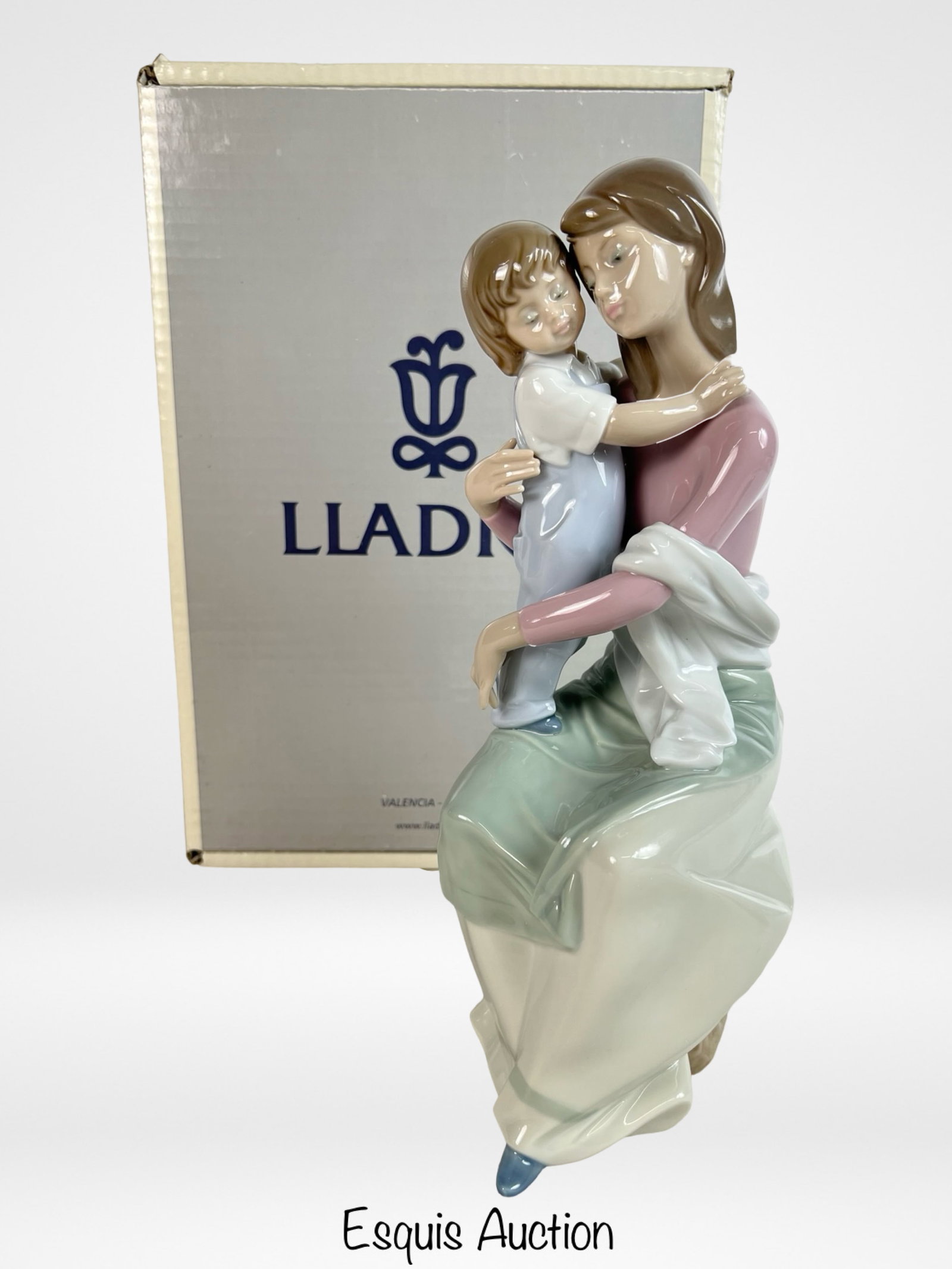 Lladro "A Mother's Love" #6634 Porcelain Figurine: Lladro porcelain figurine titled "A Mother's Love" (#6634), depicting a tender scene of a mother seated with her young child wrapped in a heartfelt embrace. Finished in Lladro's signature soft pastel 
