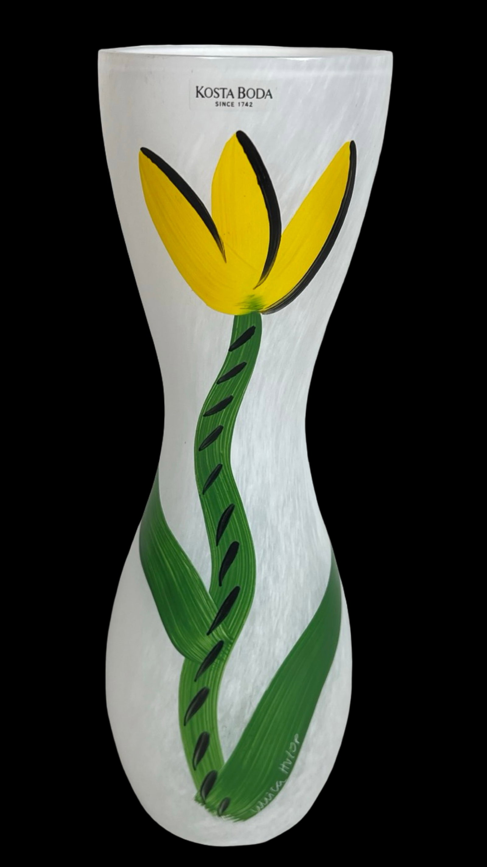 Kosta Boda Tulip Vase by Ulrica Hydman-Vallien: Elegant Kosta Boda tulip vase designed and hand-painted by Ulrica Hydman-Vallien, showcasing a bold yellow tulip with a sweeping green stem and leaves against a frosted white glass body. Signed on the