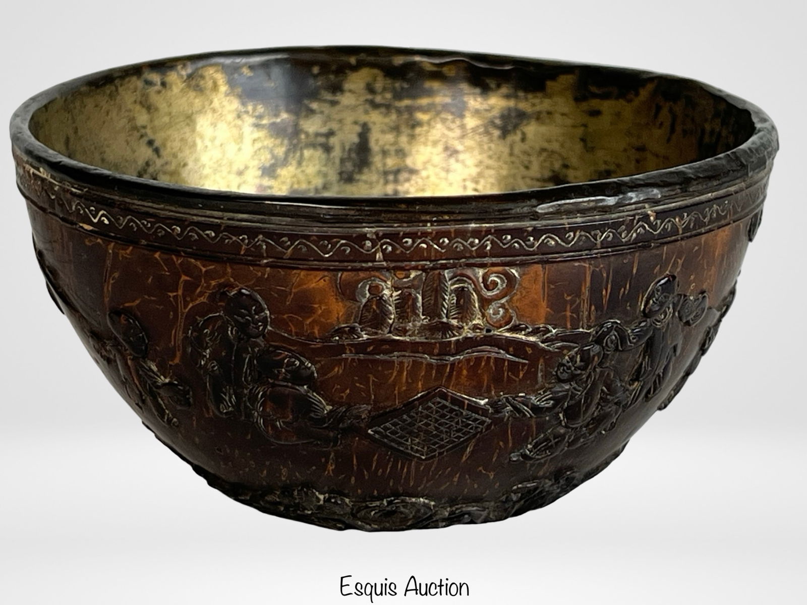 Chinese Qing Dynasty Carved Coconut Bowl: Finely carved early coconut shell bowl with thin walls, featuring raised decoration of prunus blossoms and landscape scenes bordered by a fretwork pattern. The interior retains traces of a gilt lining