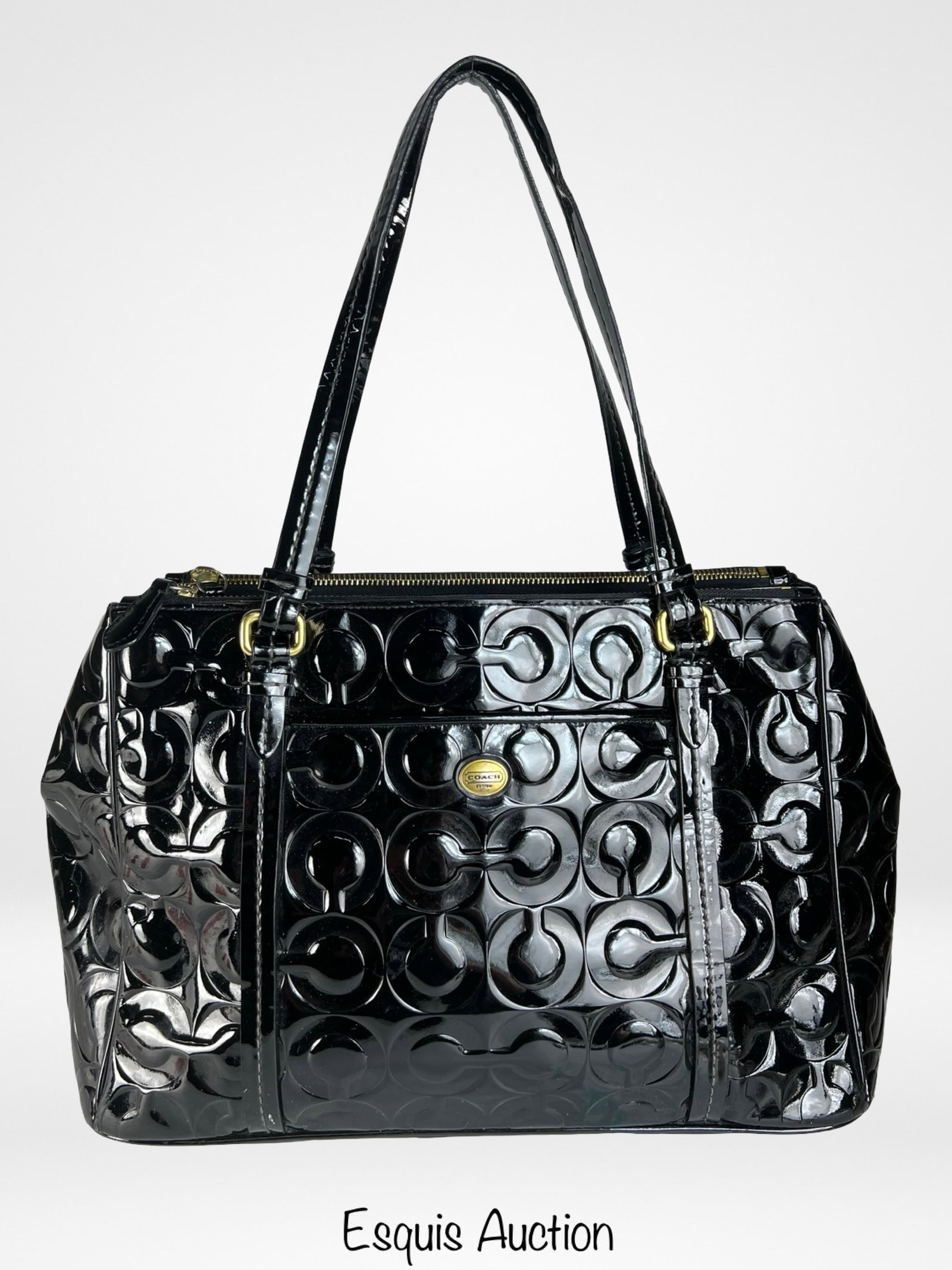 Coach Peyton Op Art Black Patent Leather Tote Bag: Sophisticated and roomy, this Coach Peyton Jordan Carryall tote is crafted from glossy black patent leather embossed with the signature Op Art pattern. The structured design includes dual leather shou