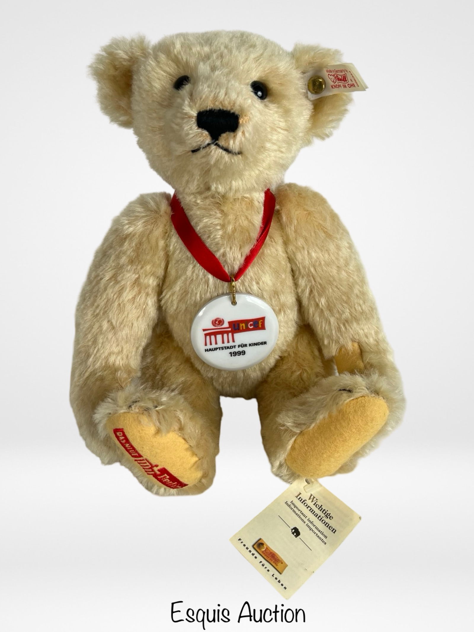 Steiff Blond Mohair1999 UNICEF Teddy Bear: Charming Steiff UNICEF Teddy Bear, issued in 1999 as a Limited Edition collectible. This 11-inch bear is crafted in blond mohair with jointed limbs and features the classic Steiff button-in-ear hallma