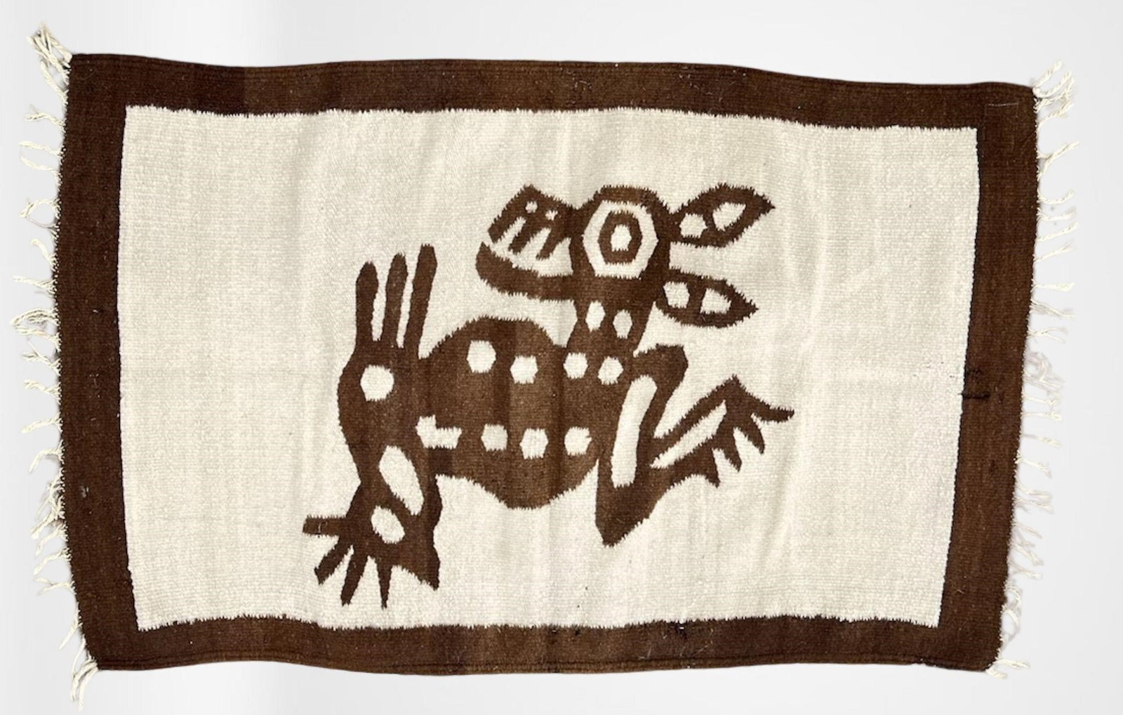Handwoven Southwestern-Style Pictorial Wool Rug: Striking handwoven wool textile featuring a bold pictorial design of a stylized zoomorphic figure rendered in deep brown against a creamy off-white field, framed by a matching brown border. The figure