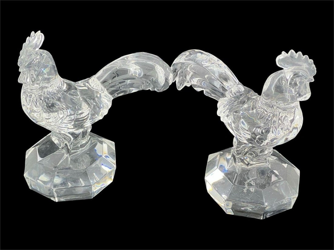 Pair of Nachtmann Clear Crystal Rooster Figurines: Elegant pair of intricately detailed clear crystal rooster sculptures by Nachtmann, a renowned German glassmaker known for its fine craftsmanship. Each rooster features a faceted base and finely textu