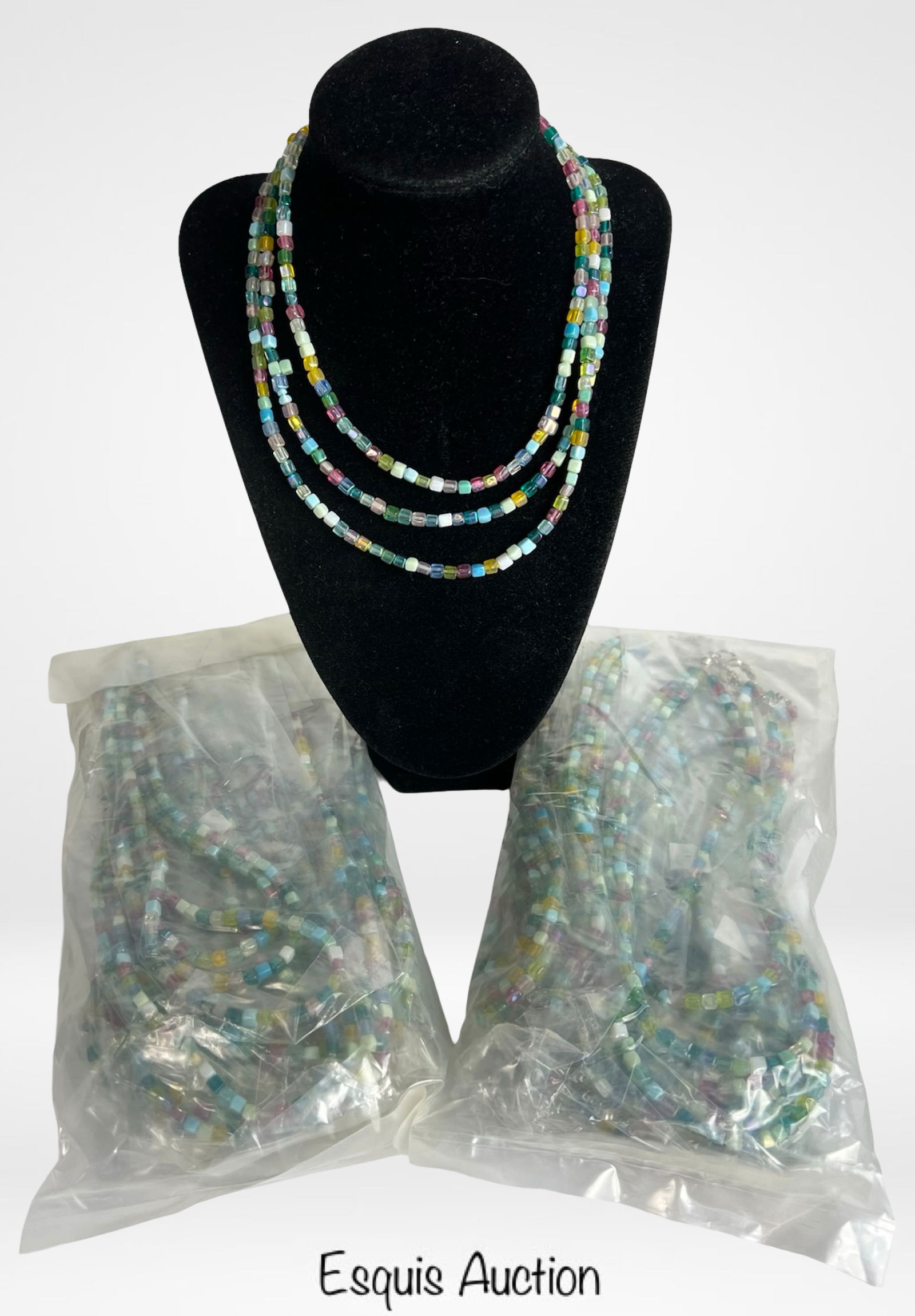 Lot of 24 Multi-Color Glass Bead Necklaces: Set of two dozen vintage necklaces composed of vibrant cube-cut glass beads in a playful mix of pastel and jewel tones. Each necklace features a continuous strand of faceted translucent beads that cat