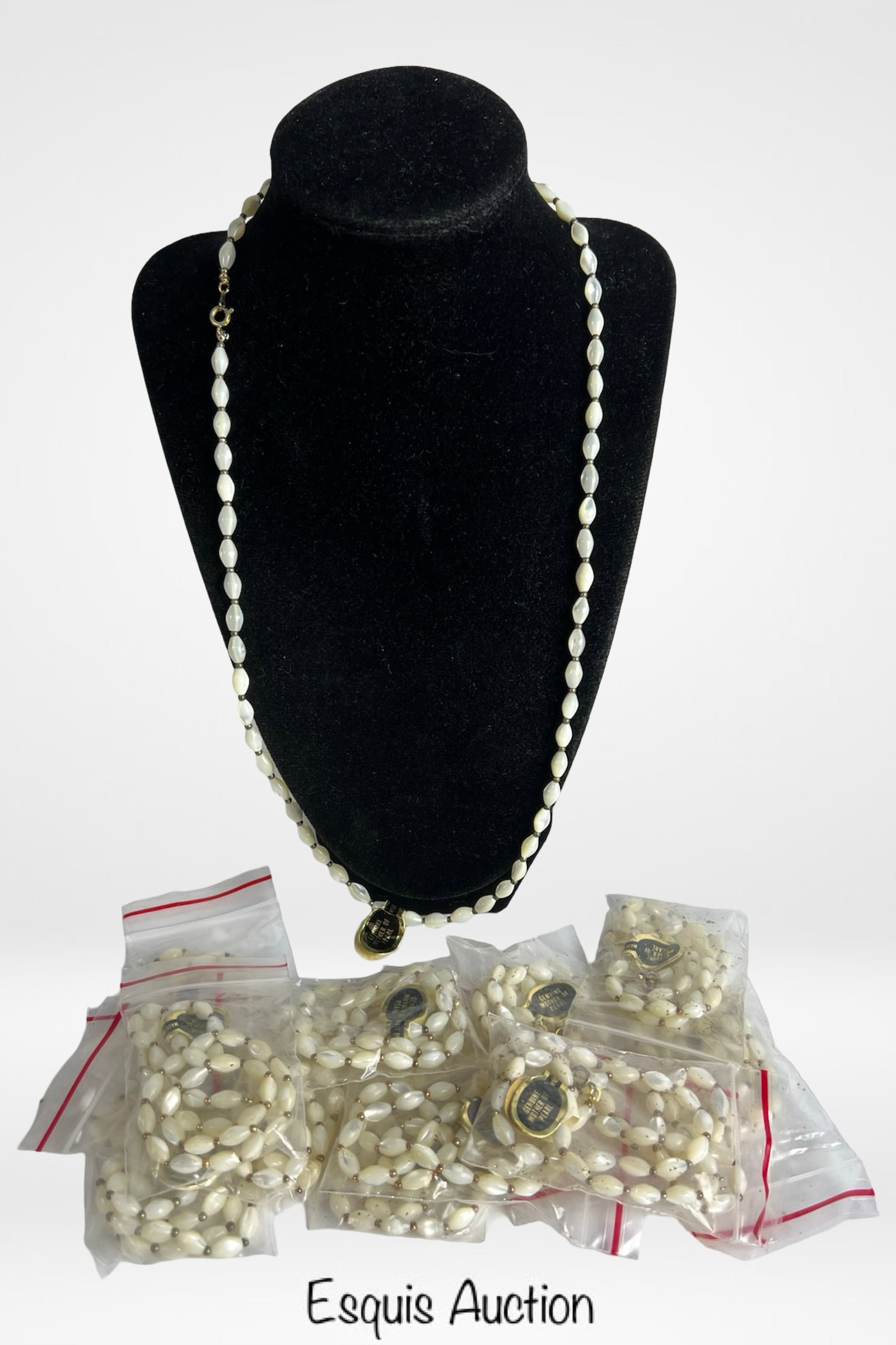 Lot of 12 Genuine Mother of Pearl Necklaces: One dozen genuine Mother of Pearl necklaces featuring lustrous elongated oval beads accented with small metallic spacers. These elegant pieces capture a soft iridescent glow and timeless appeal, ideal