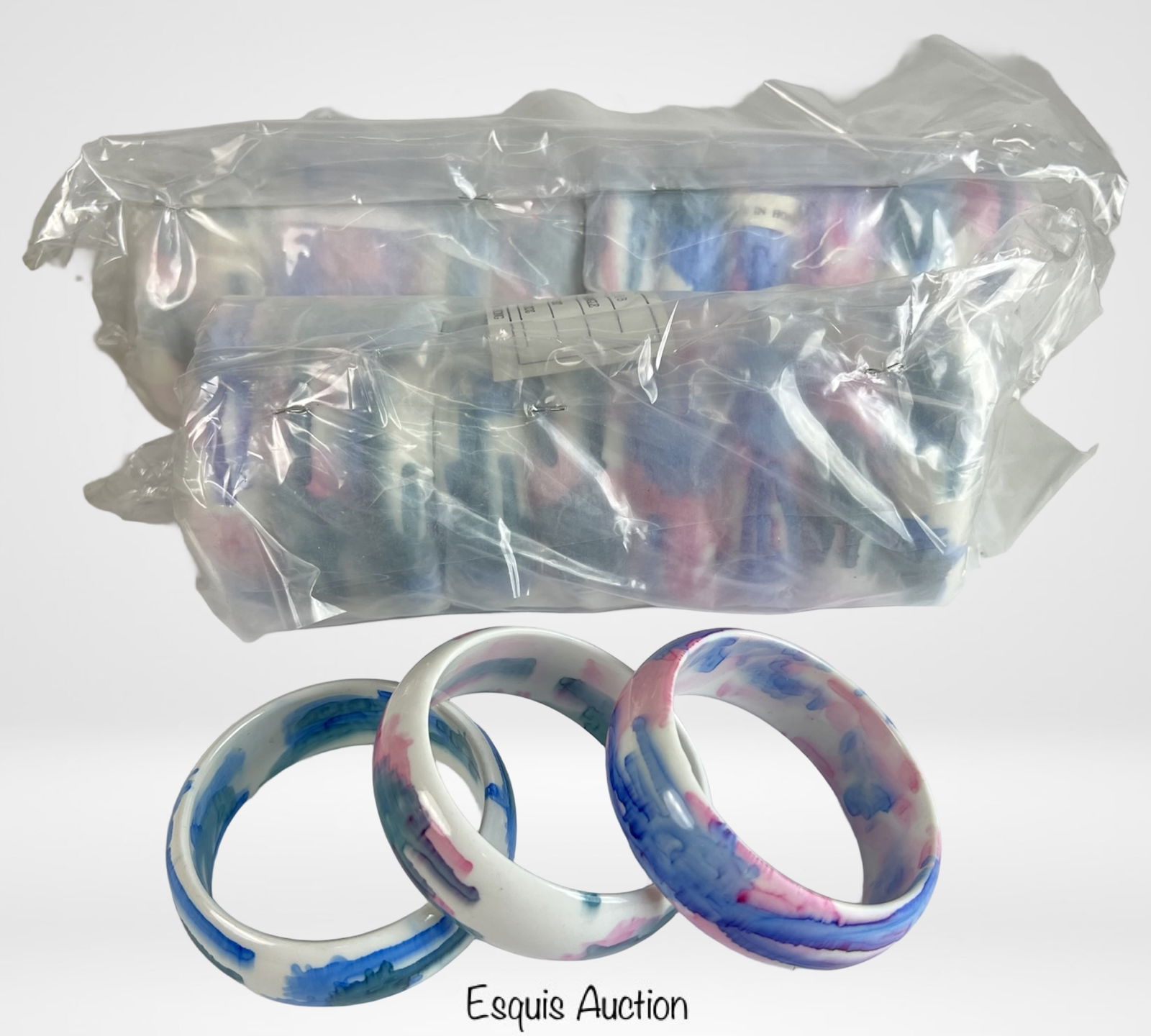 Lot of 24 Marbled Resin Bangle Bracelets: Set of 24 bold marbled resin bangle bracelets in dreamy swirls of pink, blue, and white. Each piece features a glossy finish and substantial width, offering a fun and eye-catching accessory. Sold as n