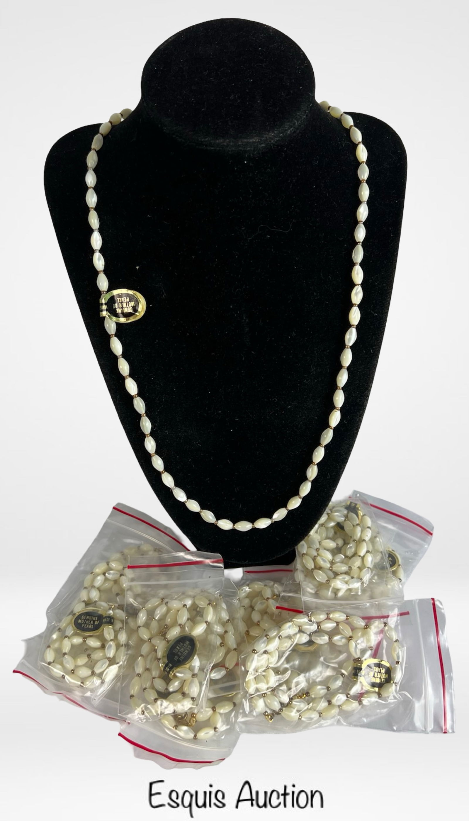Lot of 12 Genuine Mother of Pearl Bead Necklaces: Lot of 12 elegant single-strand necklaces featuring oval-shaped genuine mother of pearl beads accented with small gold-tone spacers. Each necklace retains its original "Genuine Mother of Pearl" tag an